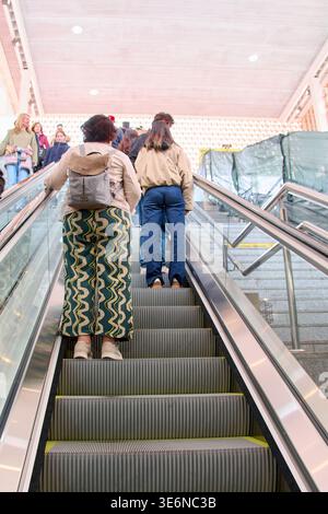 Mallorca. Spanien - 07. April 2026: Menschen, die eine Rolltreppe von den Bahnsteigen der Intermodal Station Palma fahren. Pendler mit Rucksäcken wechseln von Stockfoto