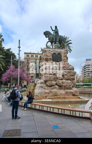 Mallorca. Spanien - 07. April 2026: Blick auf das Jaime i el Conquistador-Denkmal und den öffentlichen Brunnen mit blühenden Bäumen im Hintergrund an der Plaza de Stockfoto