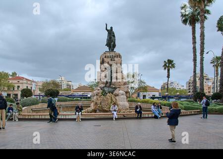 Mallorca. Spanien - 07. April 2026: Touristen entspannen sich am Brunnen an der Plaza de Espana mit dem Denkmal für König Jakob I. von Aragon unter einer bewölkten Wolke Stockfoto