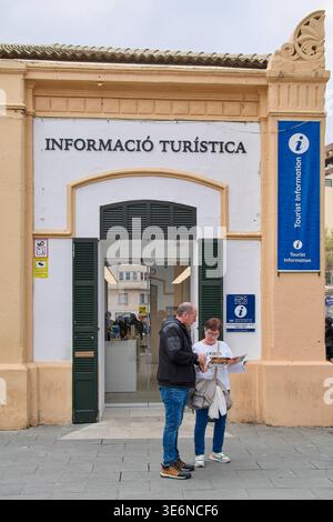 Mallorca. Spanien - 07. April 2026: Zwei Touristen stehen vor dem Büro von Informacio Turistica in Palma und schauen sich eine Karte in Papierform unter blauer Information an Stockfoto
