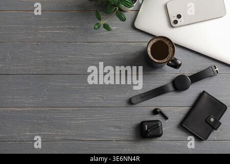Tasse Kaffee, Laptop, Handy und Smartwatch auf grauem Holztisch Stockfoto