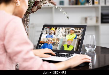Frau mit Laptop, die zu Hause Videoanrufe mit Kollegen führt Stockfoto