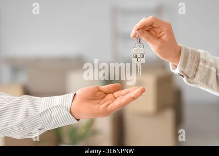 Makler gibt Schlüssel von der Wohnung an die junge Frau zu Hause, Nahaufnahme Stockfoto