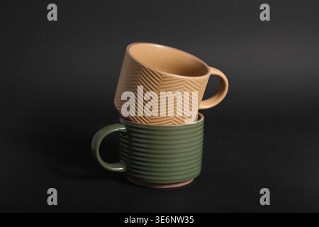 Verschiedene Keramikbecher auf schwarzem Hintergrund Stockfoto