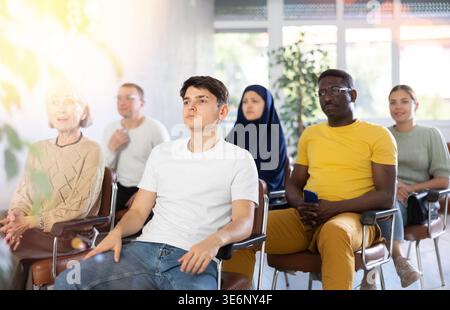 Ein Teenager hört auf dem Stuhl zu Stockfoto