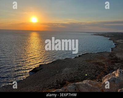Weite Meereslandschaft bei Sonnenuntergang mit felsiger Küste am Kap Greco in Zypern. Stockfoto