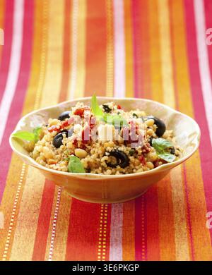 Essen, mediterraner Couscous-Salat mit getrockneten Tomaten, Feta, Oliven und Basilikum Stockfoto