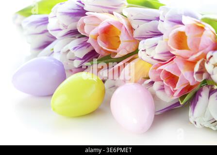 Essen, Ostereier und bunte Tulpen auf weißem Hintergrund Stockfoto