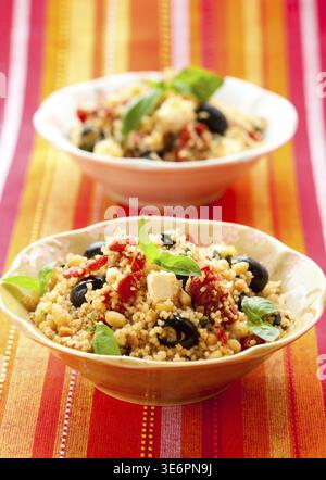 Essen, mediterraner Couscous-Salat mit getrockneten Tomaten, Feta, Oliven und Basilikum Stockfoto