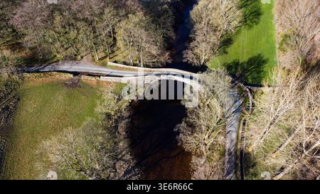 Blick aus der Vogelperspektive auf den historischen Steinbogen der Ivelet Bridge über den Fluss Swale Stockfoto