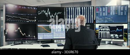 Ausgereifte, Geschäftsmann- oder Broker-Überwachung mit Börse am Computer für den Online-Handel. Rückansicht, man oder Investor überprüfen Diagrammstatistiken oder Stockfoto
