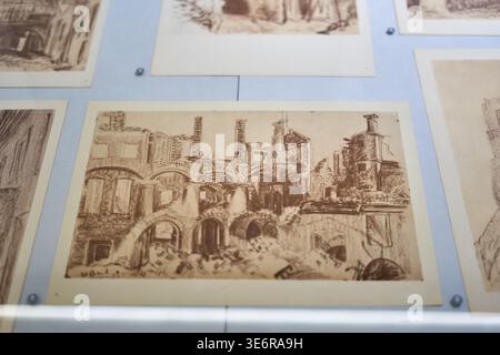 Nahaufnahme mehrerer sepiafarbener architektonischer Zeichnungen oder Radierungen, die auf einer hellblauen Anzeigetafel montiert sind, wahrscheinlich in einem Museum oder einer Galerie Stockfoto