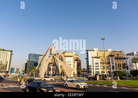 Geschäftiger Verkehr am berühmten Deira Clocktower Wahrzeichen mit moderner Architektur in Dubai, VAE. Stockfoto
