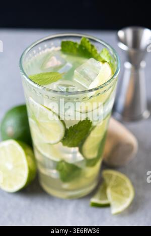 Frischer Mojito-Cocktail mit Limette, Minze und Eis im Glas auf dunklem Hintergrund Stockfoto