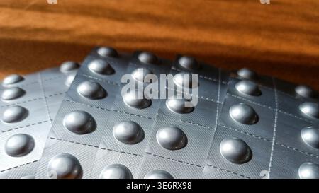 Fünf neue Blisterpackungen in Fächerform auf Holztisch Stockfoto