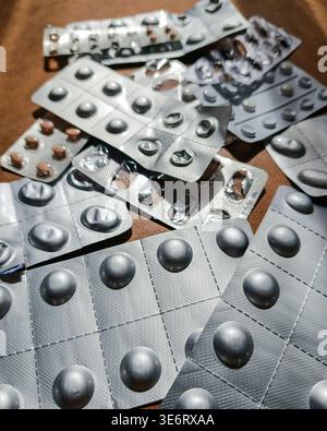 Gebrauchte Blisterpackungen mit Pillen auf Holztisch in Perspektive Stockfoto