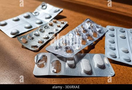 Fünf gebrauchte Blisterpackungen mit Pillen auf Holztisch, angewinkelte Ansicht Stockfoto