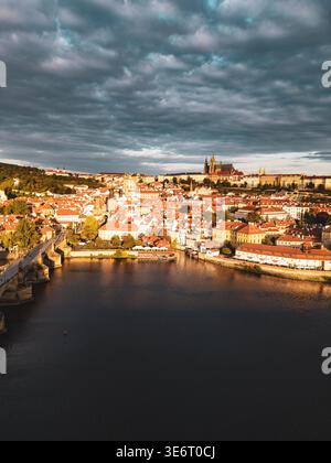 Am frühen Morgen offenbart sich die atemberaubende Skyline von Prag mit der historischen Karlsbrücke und der majestätischen Prager Burg. Die ruhige Moldau spiegelt die Farben des Himmels wider. Stockfoto