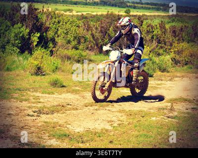 Geländegängige Enduro-Motorradfahrer fahren mit einem KTM-Dirt-Bike durch Waldwege und schlammiges Gelände in Jeffreys Bay. Südafrika Stockfoto
