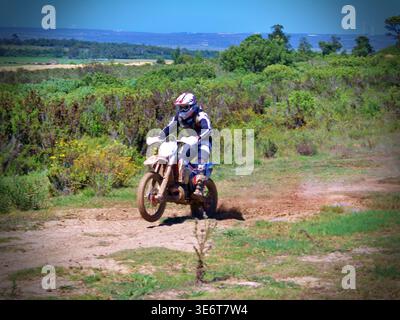 Geländegängige Enduro-Motorradfahrer fahren mit einem KTM-Dirt-Bike durch Waldwege und schlammiges Gelände in Jeffreys Bay. Südafrika Stockfoto