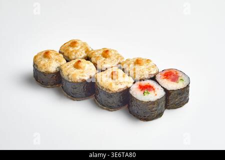 Acht Maki-Sushi-Brötchen in Nori-Algen, sechs mit goldenem Käse und Mayonnaise-Belag gebacken, zwei klassische mit rotem Tobiko-Kaviar und Gurkenfüllung, Stockfoto