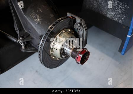 Nahaufnahme der Hinterradnabenbaugruppe eines Argo JM19 C Rennwagens mit Schlitzscheibenbremsrotor, Bremssattel und Zentralverriegelung r Stockfoto