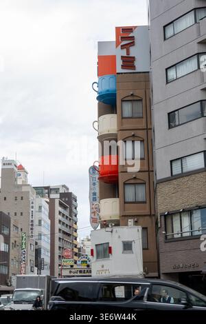 Ein Gebäude mit farbenfrohen schalenförmigen Balkonen steht in Kappabashi Kitchen Town. Das Viertel ist bekannt für seine Restaurants, Geschäfte und verspielte Architektur mit Speisen. Kappabashi Kitchen Town in Tokio ist eine Spezialitäteneinkaufsstraße, die sich mit Restaurantbedarf, Kochutensilien und Küchenutensilien befasst. Es ist vor allem für seine realistischen Plastikauslagen bekannt und zieht sowohl professionelle Köche als auch neugierige Besucher an. Stockfoto