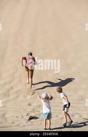 Dad und Kinder laufen auf der Sanddüne, Aerial View Stockfoto
