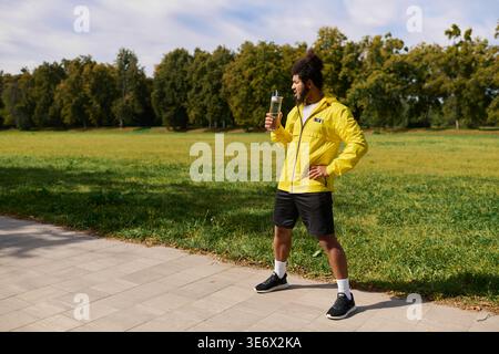 Ein energiegeladener junger Mann in leuchtend gelber Jacke nimmt Outdoor-Fitnesstraining an. Stockfoto