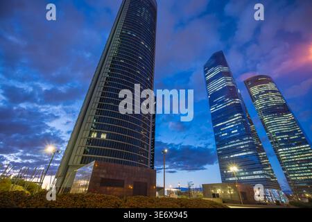 Madrid, Spanien - 14. März 2025 die beleuchteten Wolkenkratzer des Geschäftsviertels Cuatro Torres dominieren die abendliche Skyline und spiegeln Madrids modernes Archit wider Stockfoto