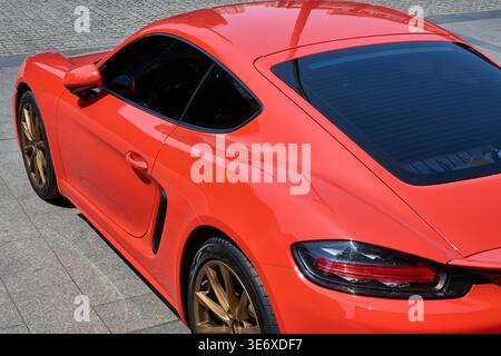 Dreiviertelansicht eines roten Porsche 718 Cayman Sportwagens auf einer asphaltierten Straße, Shanghai, China, Asien. Stockfoto