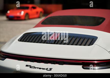 Rückansicht des weißen Porsche 911 Carrera 4S Cabriolets mit Motorgrill und rotem Faltverdeck, Shanghai, China, Asien. Stockfoto