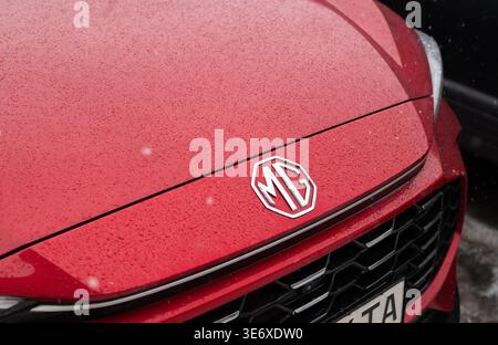 Kiew, Ukraine. Februar 2026. Rote MG-Motorhaube mit Logo in Regentropfen, Nahaufnahme des Fahrzeugs auf modernen Fahrzeugen Stockfoto
