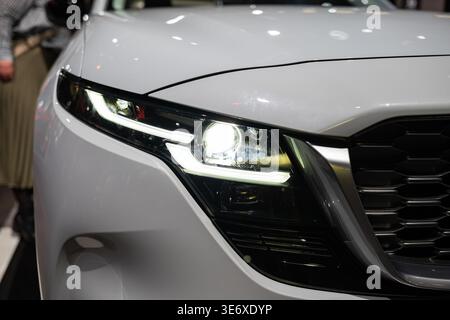 Zürich, Schweiz, 10. Oktober 2025. Detaillierte Nahaufnahme des weißen Mazda CX-60 LED-Scheinwerfers und des charakteristischen Kühlergrills des Zurich Auto SH Stockfoto