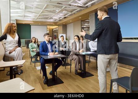 Das Unternehmensteam arbeitet mit dem Referenten bei einem Business Training Seminar im Büro zusammen Stockfoto