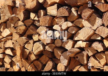Gestapelte Holzstämme. Nahaufnahme von gestapeltem Brennholz. Natürlicher Holzhintergrund. Hintergrund von gehacktem Brennholz, gebrauchsfertig. Geeignet für verwandte Themen Stockfoto