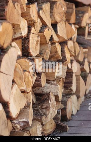 Gestapelte Holzstämme. Nahaufnahme von gestapeltem Brennholz. Natürlicher Holzhintergrund. Hintergrund von gehacktem Brennholz, gebrauchsfertig. Geeignet für verwandte Themen Stockfoto