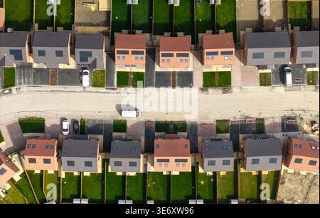 Blick von oben nach unten über einem Block neu gebauter umweltfreundlicher Vorstadthäuser in Großbritannien mit Solarpaneelen auf dem Dach und Wärmepumpen Stockfoto