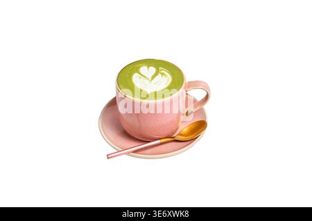 Matcha grüner Tee Latte mit Latte Art in rosa Keramik Tasse auf passender Untertasse mit goldenem Löffel, isoliert auf weißem Hintergrund. Café-Spezialgetränk-Conce Stockfoto