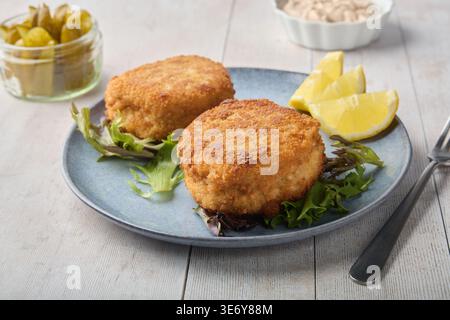 Knusprige gebratene Schnitzel mit Zitrone und frischem Salat Stockfoto