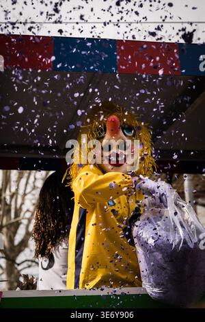 Basel, Schweiz - 10. März 2025: Blick auf eine lebendige Fasnacht-Schwärmerin unter einem Konfetti-Schauer, die den festlichen Geist der Stadt zum Ausdruck bringt. Stockfoto