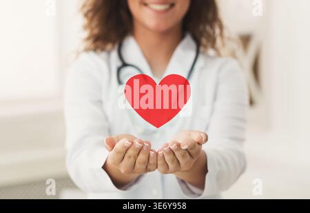 Doktor, der das rote Herz in den Händen hält Stockfoto