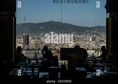 Mehrere Personen genießen einen ausgezeichneten Blick über die Stadt Barcelona, während sie im Restaurant des Nationalen Kunstmuseums von Katalonien (MNAC) essen. Montjuic ist eines der wichtigsten Touristenziele Barcelonas. Die Konzentration an Grünflächen, Wasserspielen und Museen macht es zu einem absoluten muss für Besucher. Die Esplanade vor dem Nationalen Kunstmuseum von Katalonien (MNAC) ist ein Zentrum der Aktivität. Stockfoto