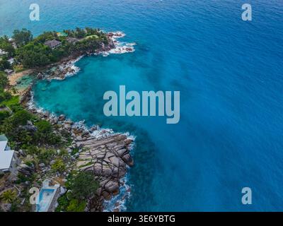 Blick aus der Vogelperspektive auf das türkisfarbene Meer mit der zerklüfteten Küste, wo das Land auf das Meer trifft, Vista do Mar, Mahe Island, Seychellen. Stockfoto