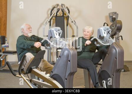 Älteres Ehepaar, das im Fitnesscenter Philadelphia, USA, Liegeräder trainiert Stockfoto