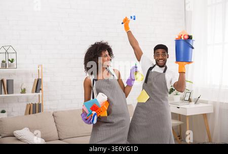 afroamerikanisches Paar mit Reinigungswerkzeugen und Reinigungsmitteln Stockfoto