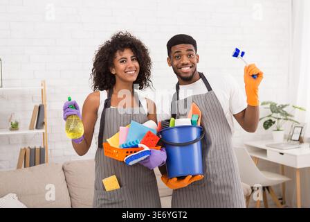 afroamerikanisches Paar mit Reinigungswerkzeugen und Reinigungsmitteln Stockfoto