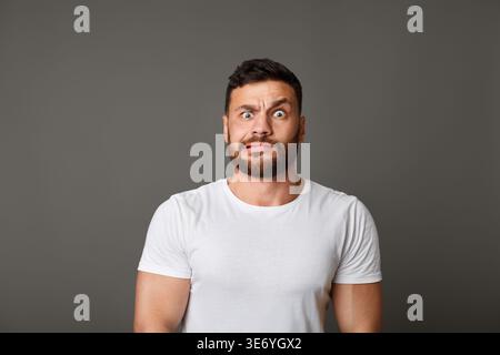 Muskulöse mann Grimassen schuldig Gesicht an Studio Stockfoto