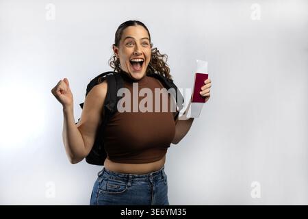 Die begeisterte Reisende Frau mit Reisepass und Bordkarte feiert die bevorstehende Reise Stockfoto