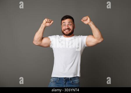 Erfolgreicher kaukasischer Mann, der geballte Fäuste in der Luft hebt Stockfoto